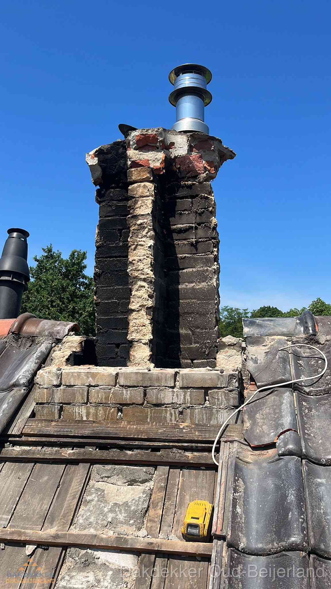 Beschadigde schoorsteen met nieuwe rookgasafvoer op oud dak in Oud-Beijerland Beschadigde schoorsteen met nieuwe rookgasafvoer op oud dak in Oud-Beijerland