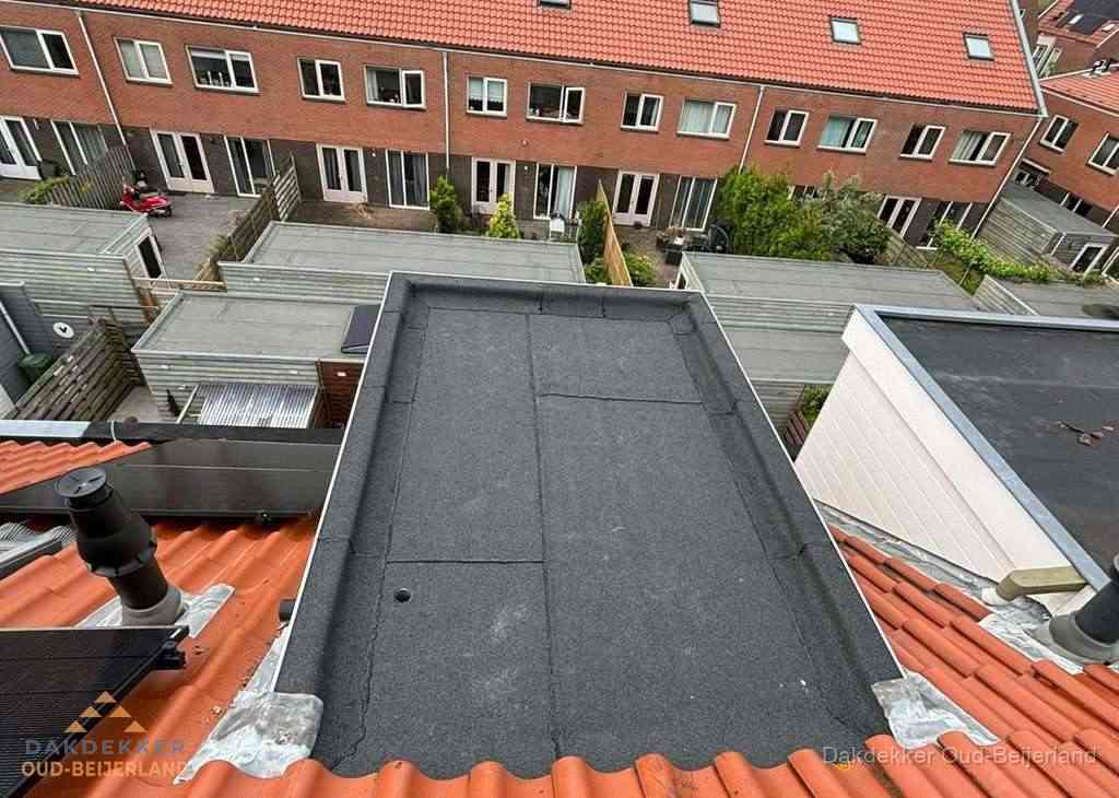 Plat dak met bitumen bedekking naast dakkapel in Oud-Beijerland