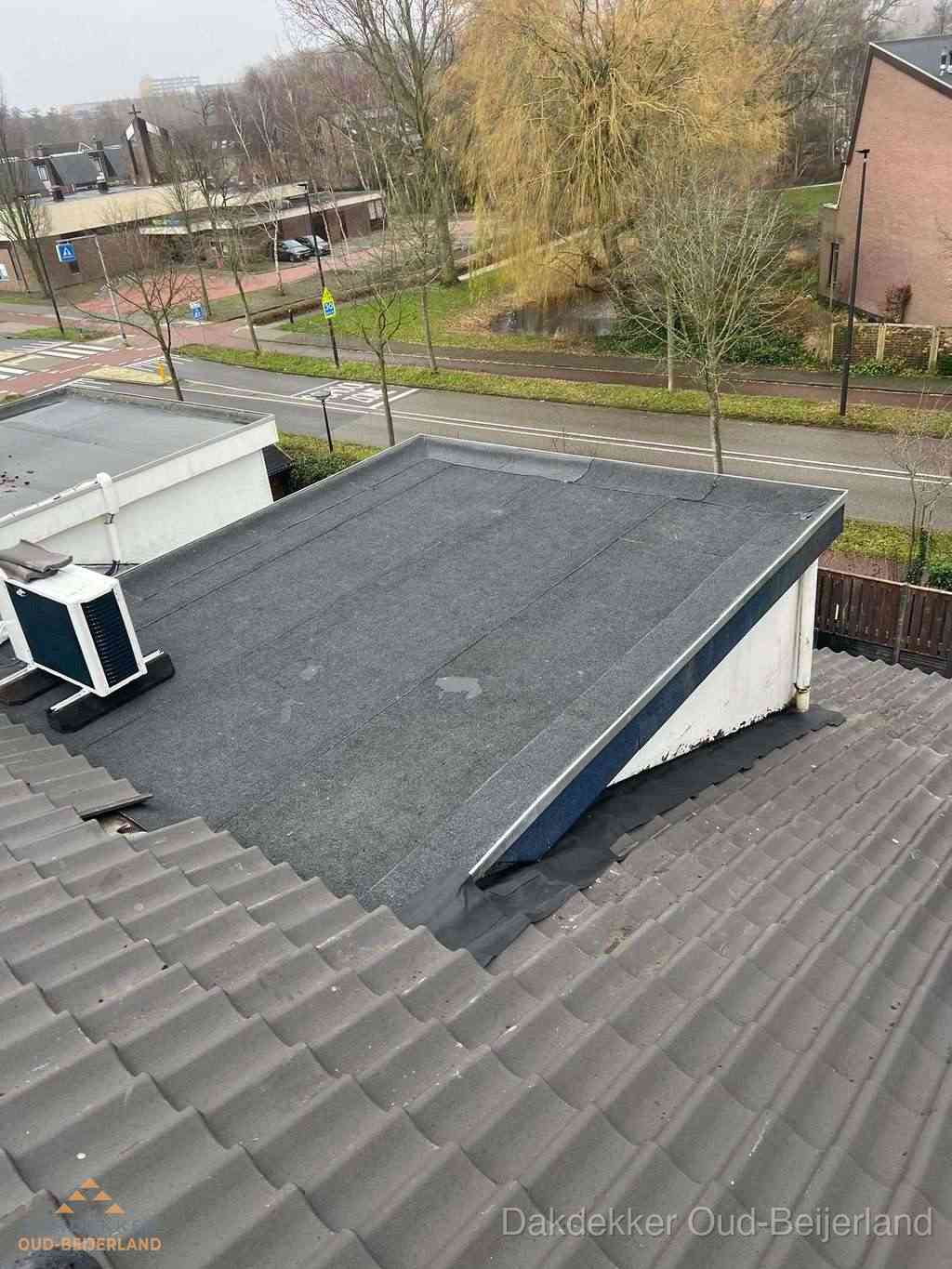 Plat dak met bitumen dakbedekking naast schuin pannendak in Oud-Beijerland