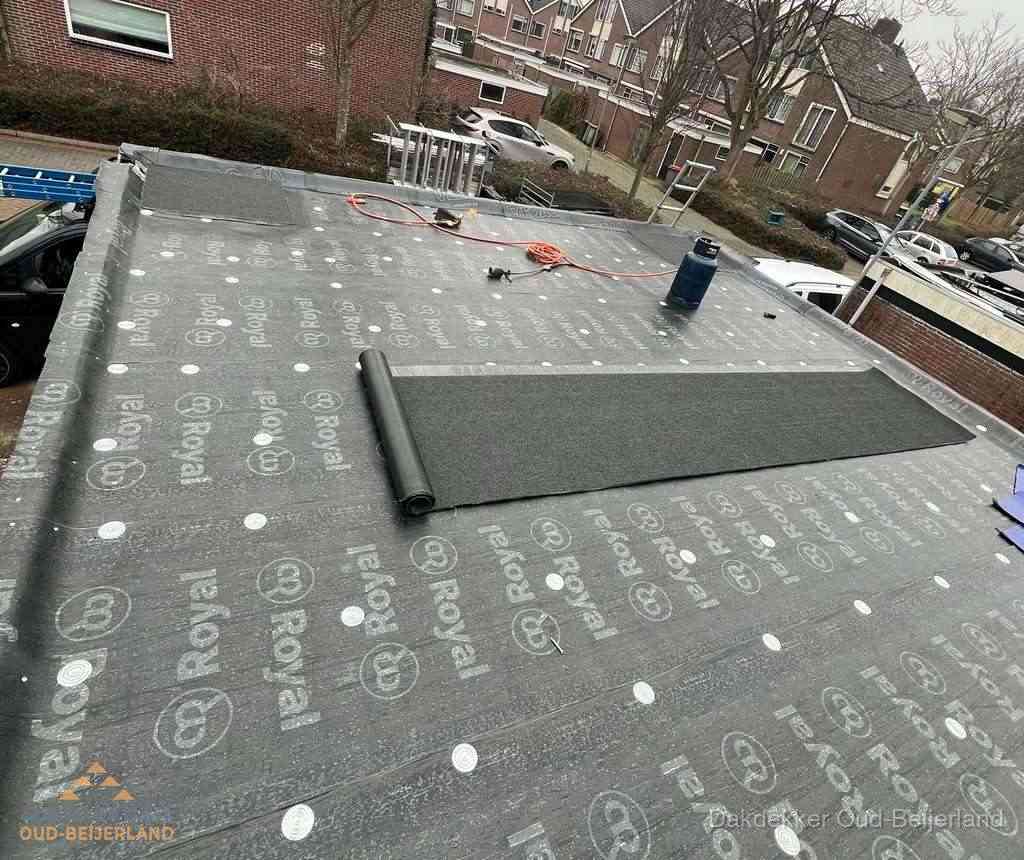 Dakdekker aan het werk met gasbrander op plat bitumen dak in Oud-Beijerland