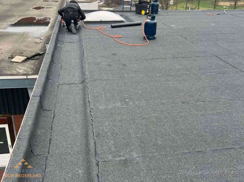 Dakdekker repareert bitumen dakbedekking op groot plat dak in Oud-Beijerland Dakdekker repareert bitumen dakbedekking op groot plat dak in Oud-Beijerland