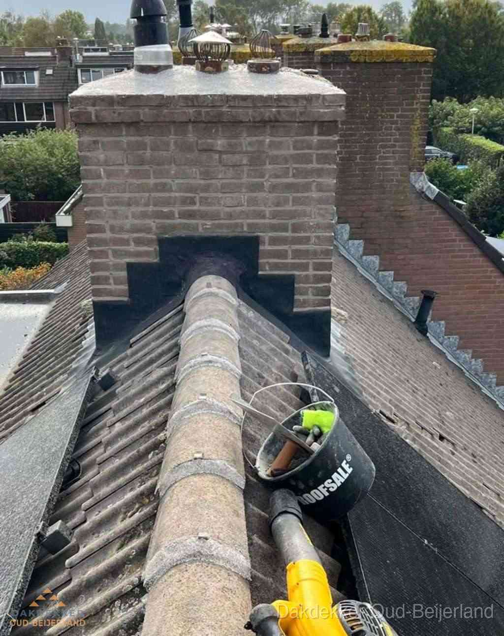 Dakdekker repareert bitumen dakleer bij dakdoorvoer in Oud-Beijerland