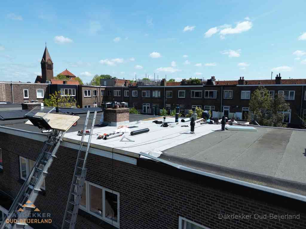 Dakdekkers aan het werk op plat dak in Oud-Beijerland Dakdekkers aan het werk op plat dak in Oud-Beijerland