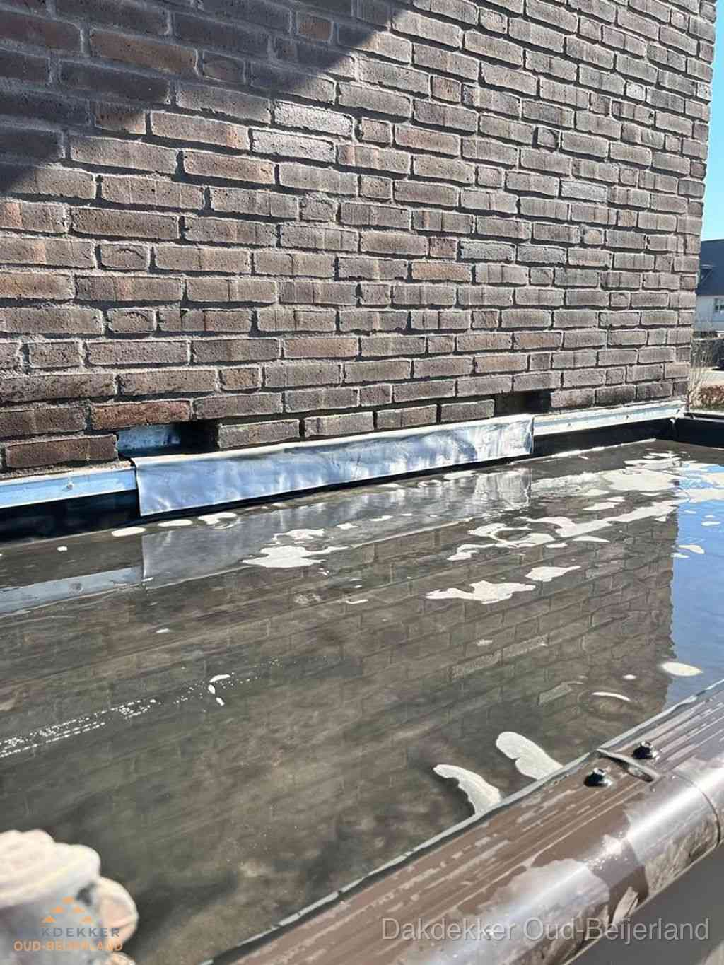 Stilstaand water op plat dak door slechte afwatering in Oud-Beijerland Stilstaand water op plat dak door slechte afwatering in Oud-Beijerland